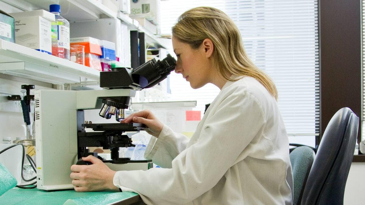 5 Reasons BioLongevity Labs is a Top Research Peptide Company in the USA 1 A peptide synthesis lab technician looks into a microscope